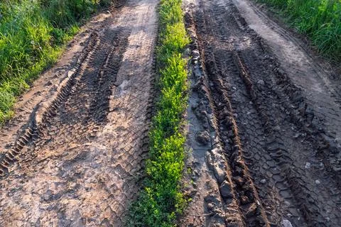 A deep car track on a Russian dirt road after rain. The imprint of car tires  Stock Photos