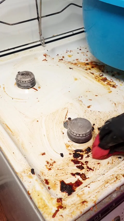 Deep cleaning a very dirty gas hob with a sponge and black gloves Stock Footage 341937080