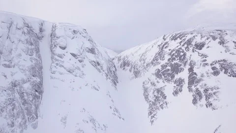 Deep cold ravine runs between high sharp mountain peaks Stock Footage 112537109