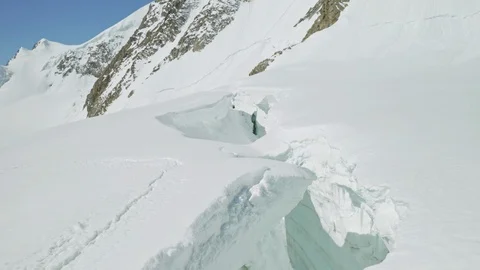 Deep collapsed hollow in dense snow, frozen dangerous highland grotto, icicles Stock Footage 126365512