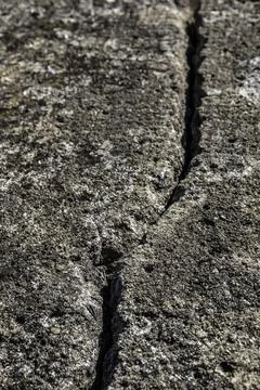 Deep crack in the big rock of the wall of a castle Stock Photos
