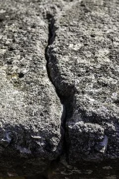 Deep crack in the big rock of the wall of a castle Stock Photos