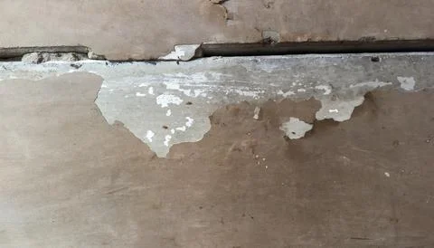 Deep crack in ceiling between concrete slabs with peeling paint indoors, ol.. Stock Photos