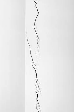Deep crack in the white wall in close-up. Plaster cracked. Problems of cons.. Stock Photos