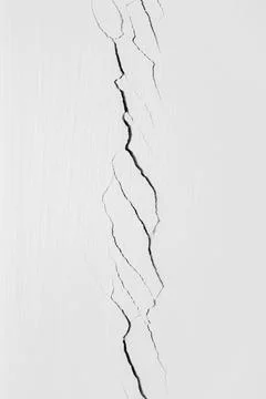 Deep crack in the white wall in close-up. Plaster cracked. Problems of constr Stock Photos