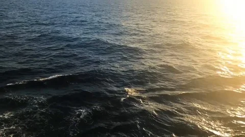 Deep dark ocean overview to golden sun setting on ocean surface Stock Footage 97179443