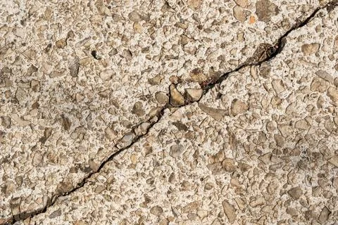 Deep Diagonal Crack on Old Weathered Concrete Surface with Stones Texture. Stock Photos