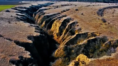 Deep Earth Cracks in Dry Desert Terrain Stock Footage 322829432