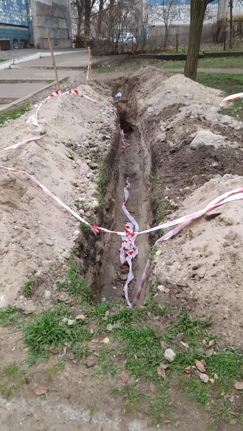 Deep Earthen Trench with Red and White Safety Tape Stock-Footage 326202595