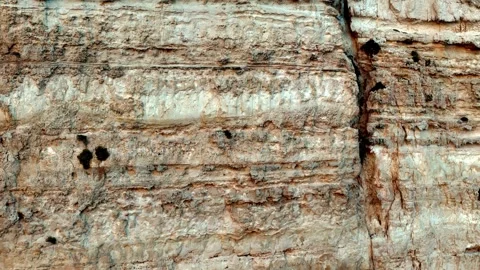 Deep eye level shot of a rugged limestone cliff face featuring dramatic Stock Footage 327428456