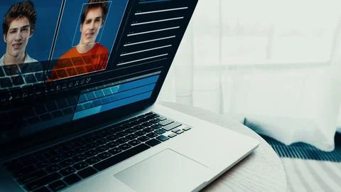 Deep fake technology displays two faces on a laptop screen in a bright room 스톡 사진