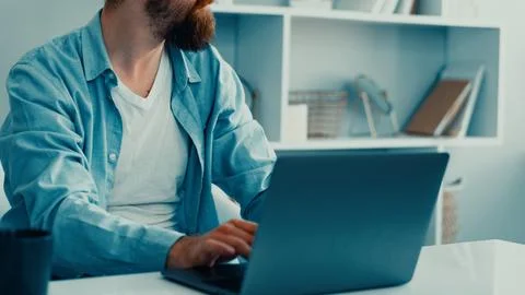 Deep fake technology used in a workspace setting with a man typing on a laptop Stock Photos