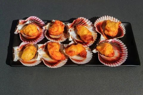 Deep-fried battered scallops in its shell on a table Stock Photos