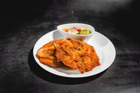 Deep-fried battered shrimp sheets with dipping sauce on a black plate. Stock Photos
