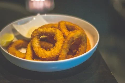 Deep fried breaded Calamari served with Garlic Aioli in a white dish Stock Photos