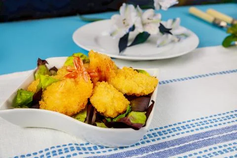 Deep fried breaded shrimps with salad and table set. Stock Photos