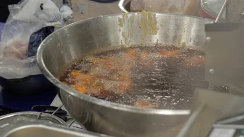 Deep fried chicken drums and wings are being cooked in a hot oil pot Stock Footage 204966617