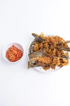 Deep fried crispy catfish served with spicy red chili paste sambal isolated.. Stock Photos