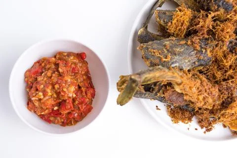 Deep fried crispy catfish served with spicy red chili paste sambal isolated.. Stock Photos