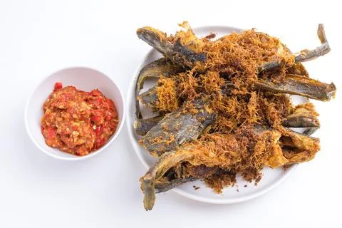 Deep fried crispy catfish served with spicy red chili paste sambal isolated.. Stock Photos