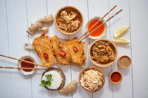 Deep fried Crispy chicken in breadcrumbs served on white wooden table with salad Stock Photos