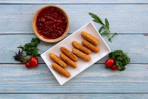 Deep fried crispy mozzarella cheese sticks with tomato dipping sauce isolated Foto stock
