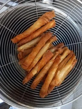 Deep Fried Crispy Spring Roll Skins Top View in Metal Strainer Fotos Stock