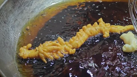 Deep fried dough stick in dragon shape fried in boiling oil. Stock Footage 305232923