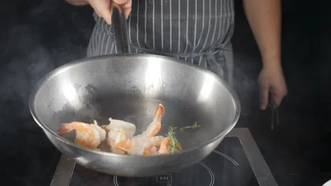 Deep fried large shrimps on frying pan being tossed and stirred. Close up. slow Stock Footage 119857733