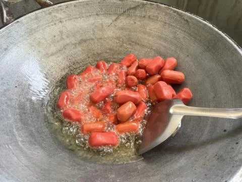 Deep Fried Red Mini Sausages Cooking in a Metal Wok with Hot Oil Stock Photos