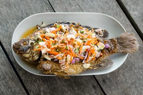 Deep fried red tilapia with herb and spicy sauce Stock Photos