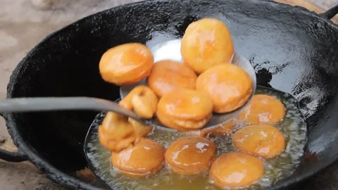 Deep fried round dough in the hot oil taken out Stock Footage 162971317