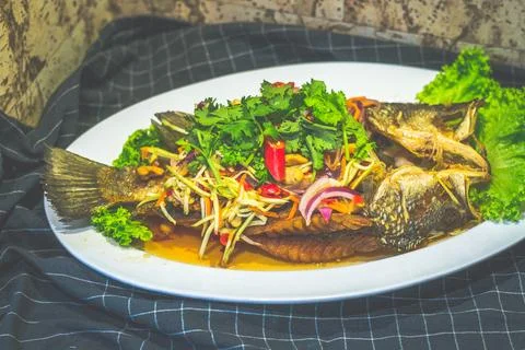 Deep Fried Seabass topeed With Mango Salad and served on a plate Stock Photos