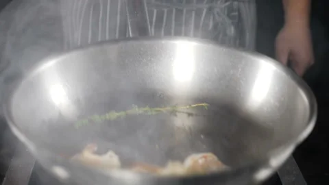 Deep fried shrimps preparing on frying pan. Shrimps are being tossed, mixed and Stock Footage 120302430