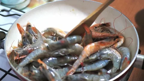 Deep fried shrimps preparing frying pan. Shrimps are tossings, mixing and Stock Footage 140682039