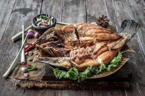Deep fried Snapper with fish sauce on vintage wooden. Stock Photos