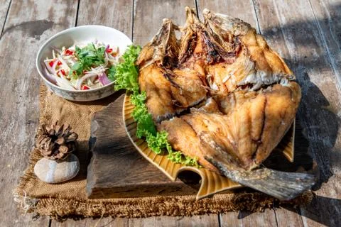 Deep fried Snapper with fish sauce on vintage wooden. Stock Photos
