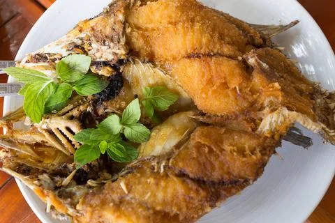 Deep fried snapper topped with sweet fish sauce with herbs Stock Photos