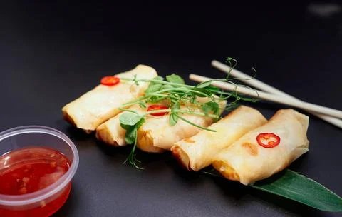 Deep fried spring rolls with red sauce on black background 写真素材