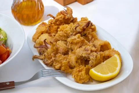 Deep-fried squid and fork on white tablecloth Stock Photos