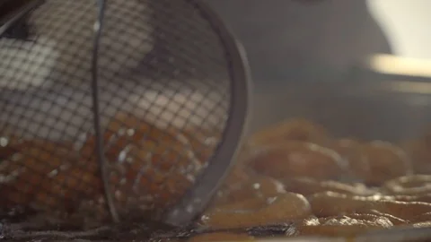 Deep frying and stirring dough soaked in syrup. 스톡 동영상 99832645