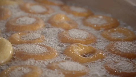 Deep frying and stirring dough soaked in syrup. 스톡 동영상 99835073
