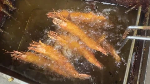 Deep frying breaded ebi fry shrimp in bubbling hot oil, izakaya kitchen, Japan Stock Footage 343376288