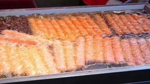 Deep frying is a cooking method in which food is submerged in hot fat Stock Footage 264962850