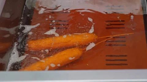 Deep frying is a cooking method in which food is submerged in hot fat Stock-Footage 265664442