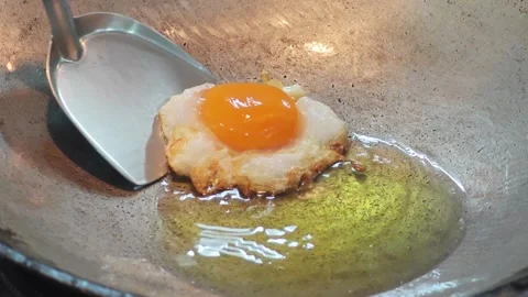 Deep frying a crispy egg with runny yolk in a Thai wok. 스톡 동영상 343697963