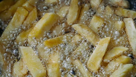 Deep frying crispy golden french fries in a pan with hot boiling oil. Stock Footage 338341653
