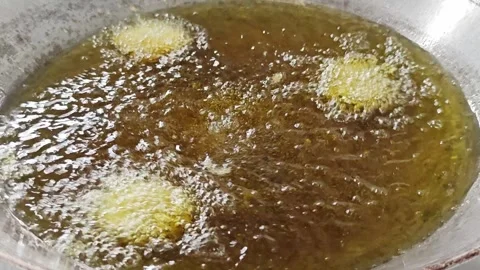 Deep frying food in hot boiling oil with a metal spatula. Stock Footage 342686516