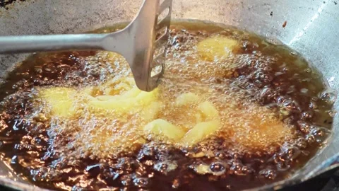 Deep frying fresh onion rings in hot boiling oil. 库存影片 344561605