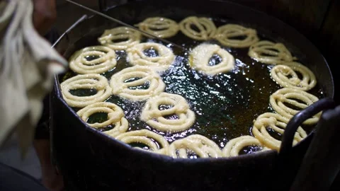 Deep frying Jalebi sweets on the streets of Dhaka at night Stock Footage